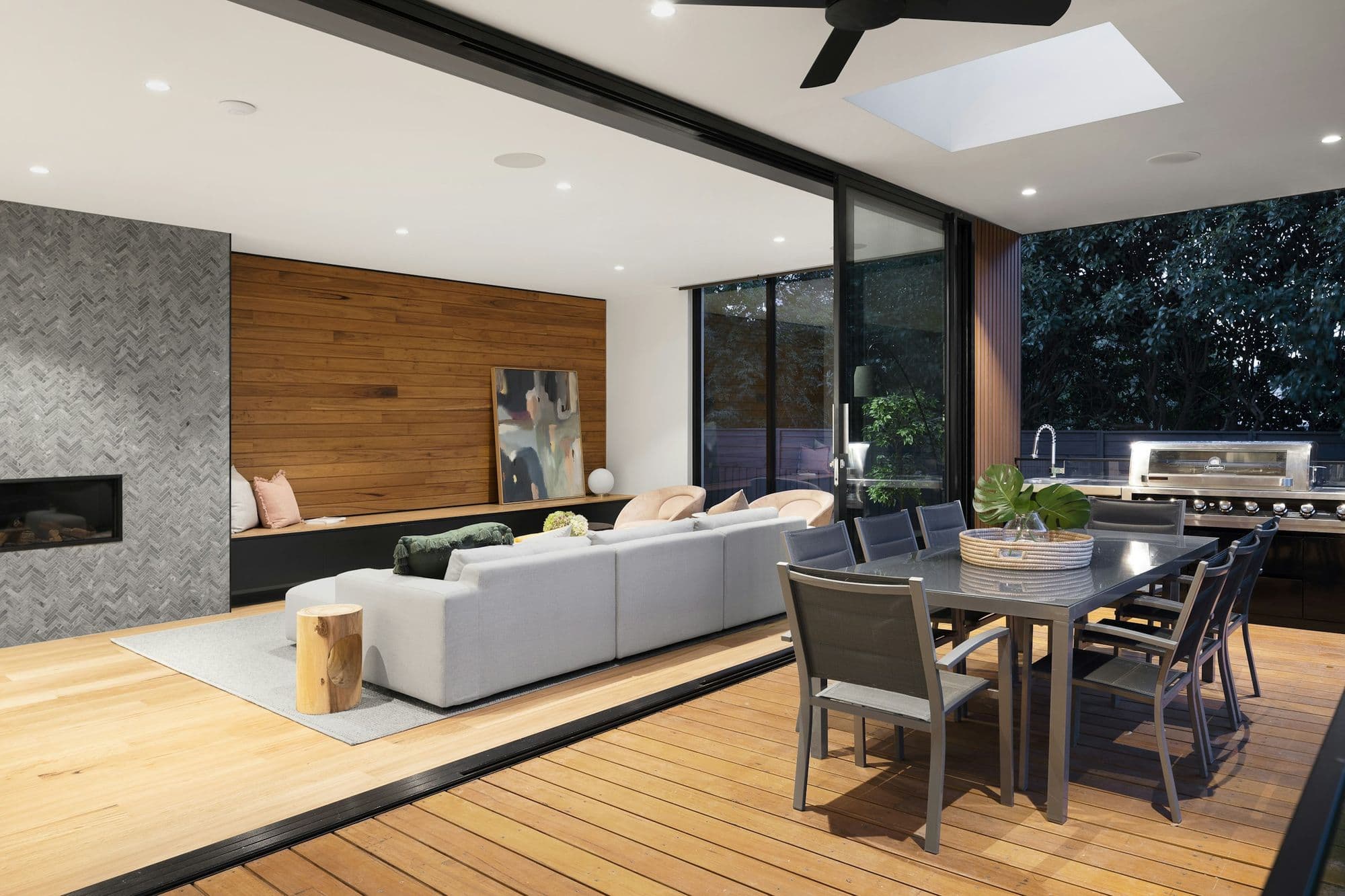 Open-plan kitchen and living space with a stone feature wall and oak floor