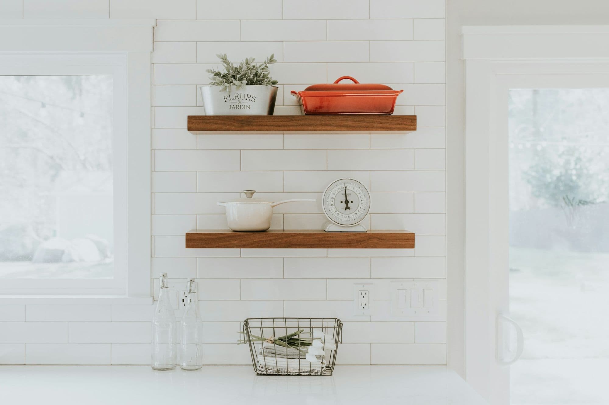 Oak open shelves against white tiling, holding ceramics